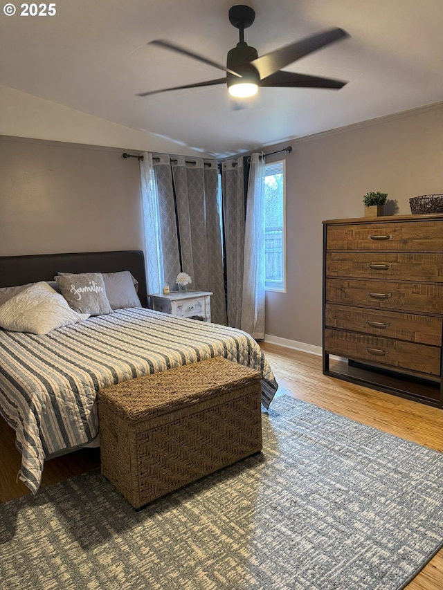 bedroom featuring hardwood / wood-style flooring, ceiling fan, and crown molding