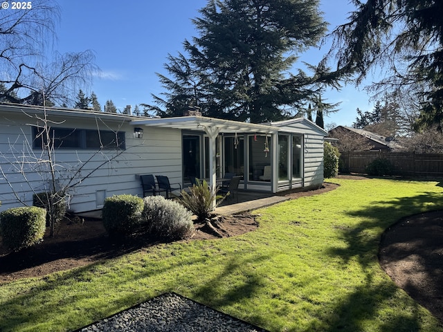 rear view of property with a lawn