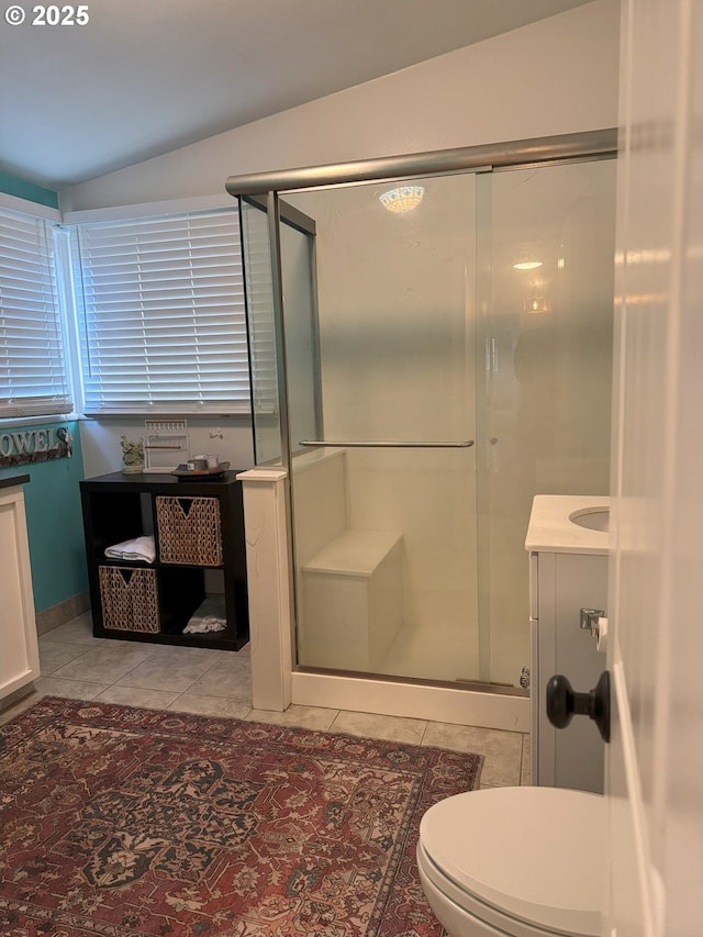 bathroom featuring lofted ceiling, toilet, walk in shower, and tile patterned floors