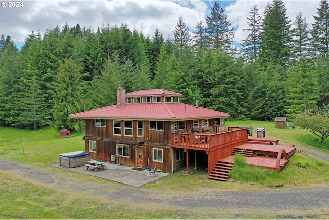 back of property featuring a patio, a hot tub, and a deck