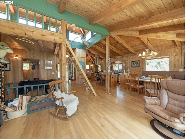 living room with wood walls, wooden ceiling, lofted ceiling with beams, a notable chandelier, and light hardwood / wood-style floors