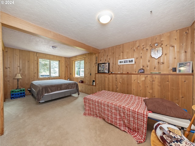 carpeted bedroom featuring wood walls, beamed ceiling, and a textured ceiling