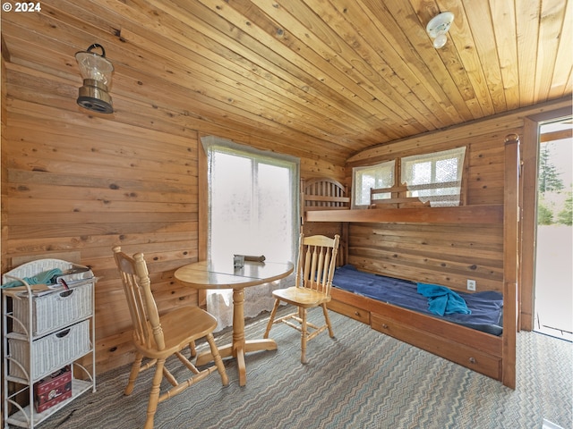 living area featuring lofted ceiling, wood walls, and wood ceiling