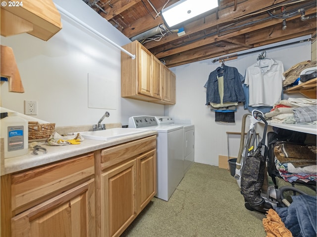 clothes washing area featuring cabinets, washing machine and dryer, and sink