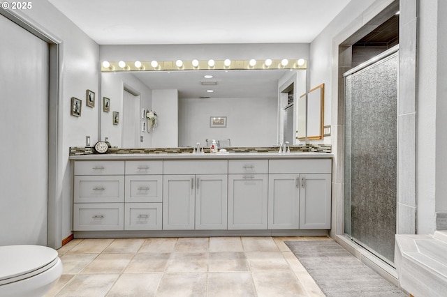 bathroom featuring toilet, a shower with door, vanity, and tile patterned floors