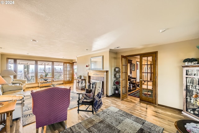 living room with light hardwood / wood-style flooring, french doors, a brick fireplace, and crown molding