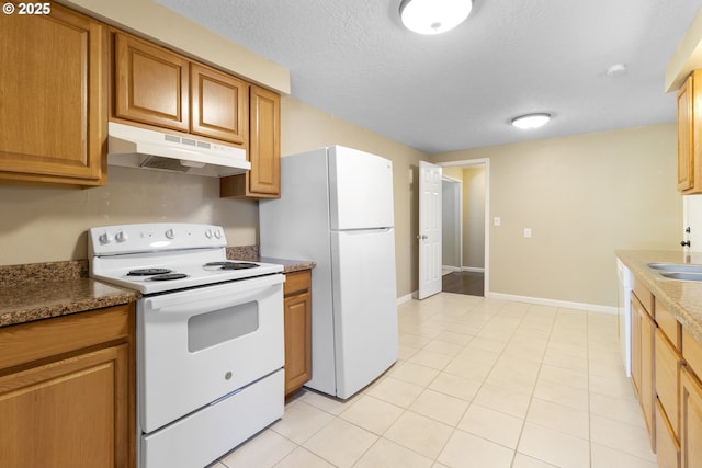 213 Engle Ave, Molalla, OR 97038 - kitchen with white appliances, under cabinet range hood, light tile patterned flooring, brown cabinets, and a textured ceiling