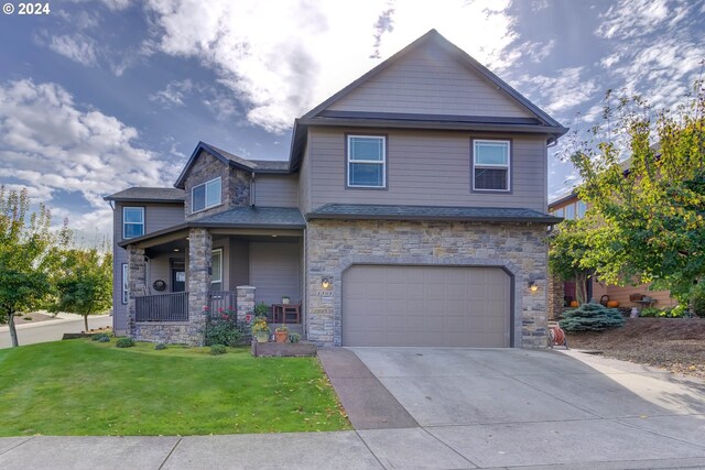 view of front of property featuring a front lawn, a porch, and a garage