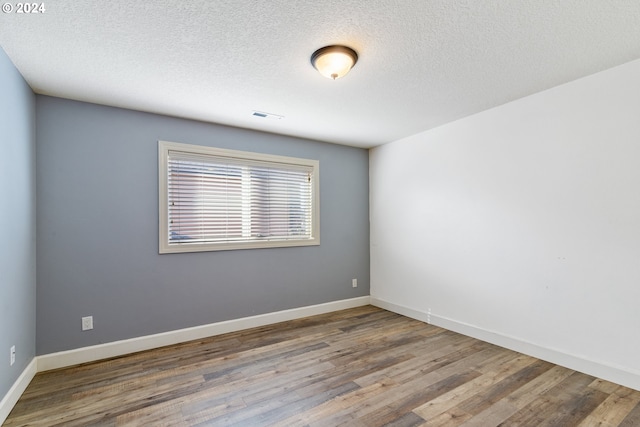 spare room with wood-type flooring and a textured ceiling