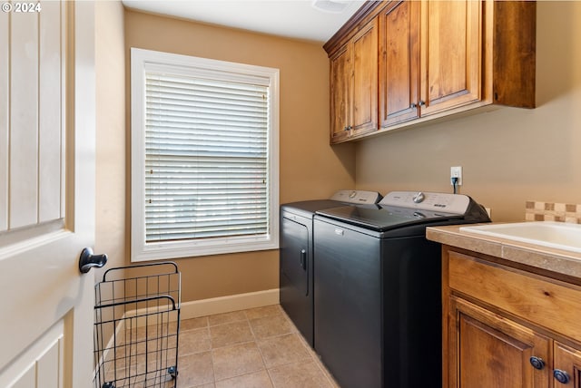 laundry room featuring cabinets, washing machine and clothes dryer, and light tile patterned flooring