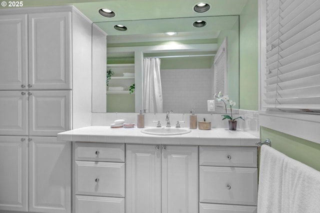 full bath with curtained shower, recessed lighting, and vanity