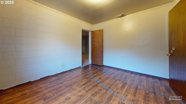 empty room with dark hardwood / wood-style flooring and a textured ceiling