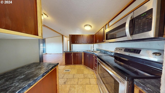 kitchen featuring sink, stainless steel appliances, and a textured ceiling