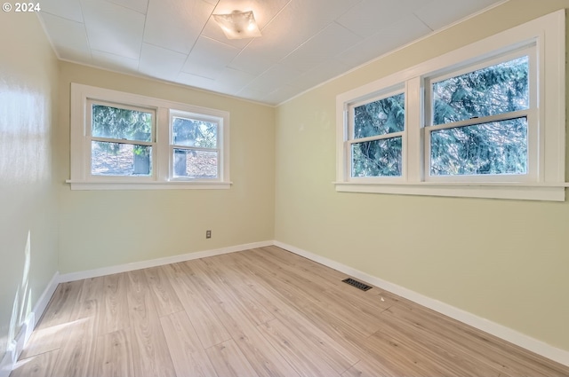 unfurnished room featuring light wood-type flooring and crown molding