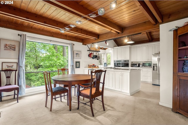 dining room with beamed ceiling, light colored carpet, rail lighting, and wood ceiling