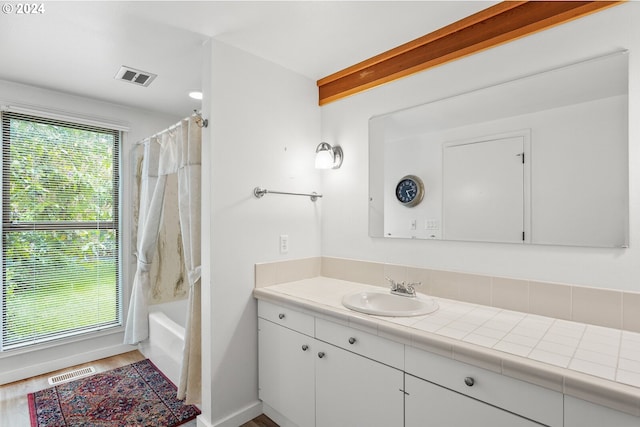 bathroom featuring wood-type flooring, shower / bath combo, and vanity