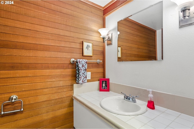 bathroom featuring wood walls and vanity with extensive cabinet space