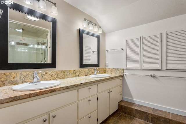 bathroom with double vanity, tile flooring, and vaulted ceiling