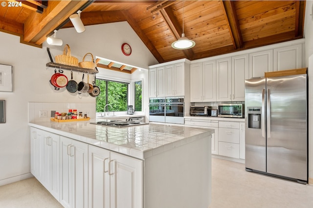 kitchen with appliances with stainless steel finishes, wood ceiling, beamed ceiling, and white cabinetry