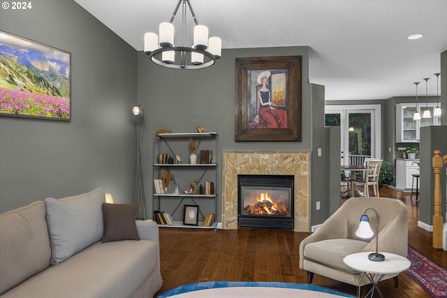 living room with hardwood / wood-style floors, a notable chandelier, and a fireplace