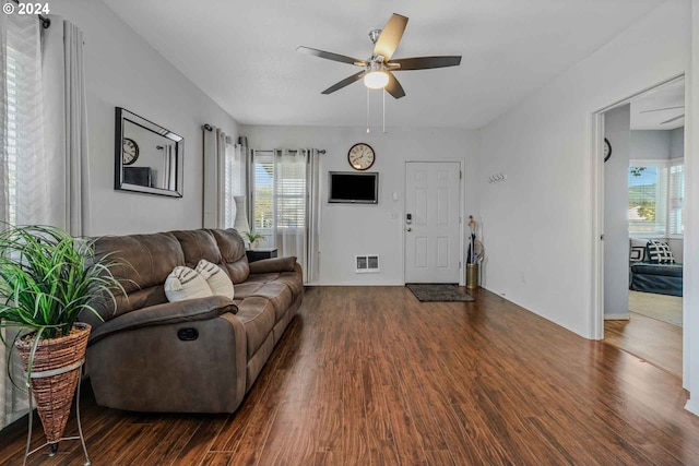 living room with a healthy amount of sunlight, dark hardwood / wood-style flooring, and ceiling fan