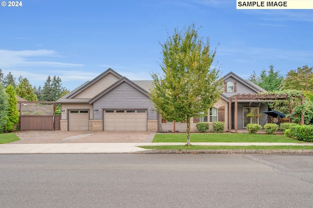 view of front of house with decorative driveway, fence, an attached garage, a front yard, and brick siding