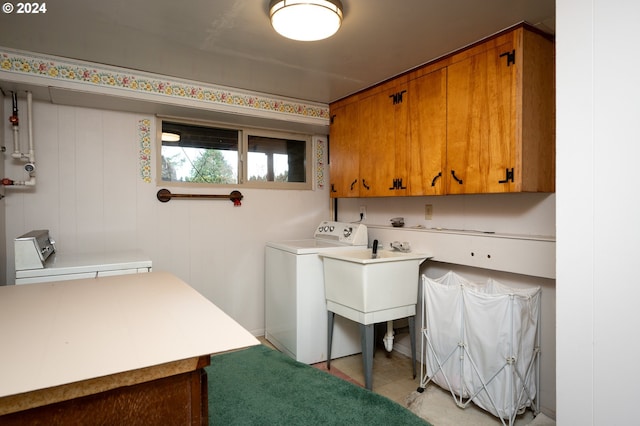 washroom with washer / clothes dryer, wooden walls, sink, and cabinets