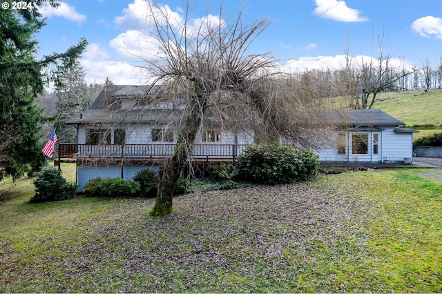 rear view of house with a lawn and a wooden deck