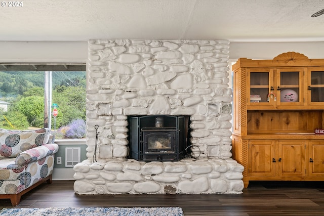 interior space with a textured ceiling, wood-type flooring, and a stone fireplace