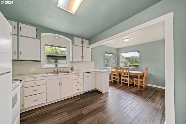 kitchen with a wealth of natural light, white appliances, and white cabinetry