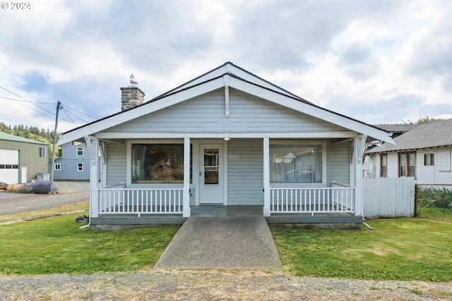 bungalow-style home featuring a garage, a porch, and a front lawn