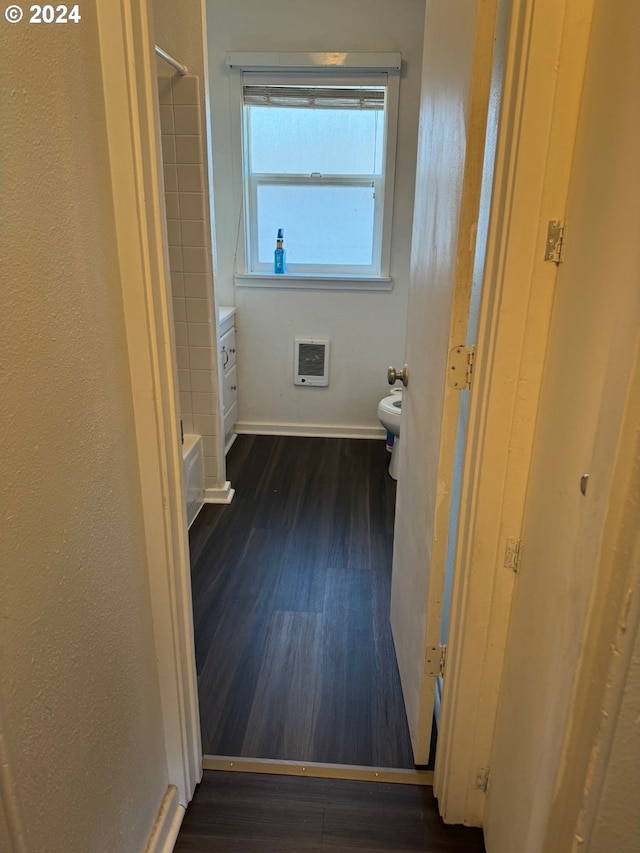 hallway with heating unit and dark hardwood / wood-style flooring