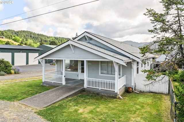 bungalow-style house featuring a garage, a porch, and a front lawn