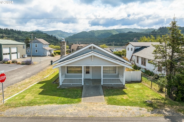 bungalow-style home with a porch, a front lawn, and a mountain view