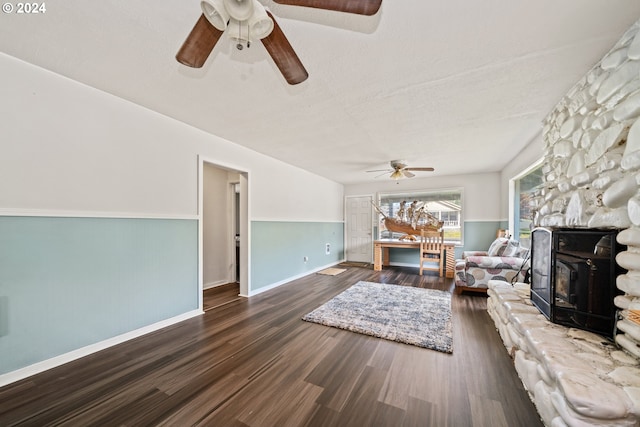 living room with dark wood-type flooring, ceiling fan, and a fireplace