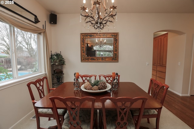 dining space with wood-type flooring and a chandelier