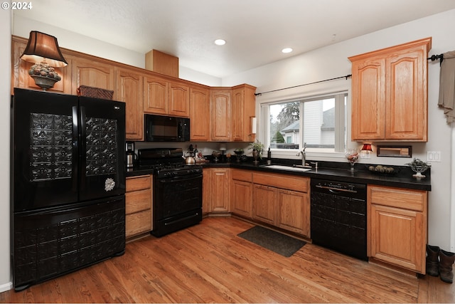 kitchen with sink, light wood-type flooring, and black appliances