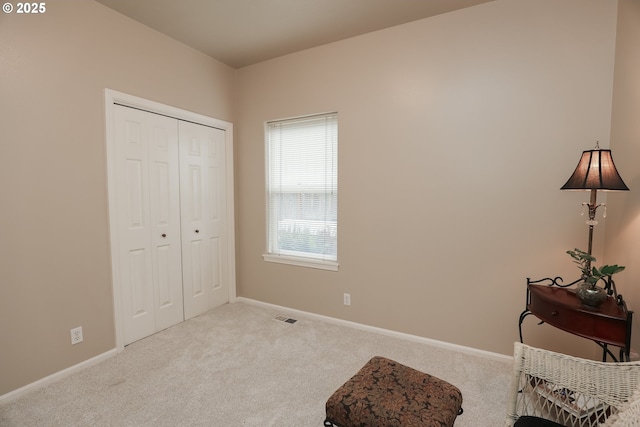 living area featuring light carpet