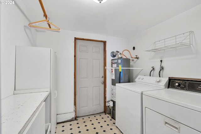 washroom featuring cabinets, gas water heater, and independent washer and dryer