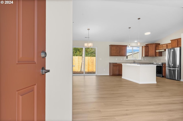 kitchen with a center island, hanging light fixtures, tasteful backsplash, light hardwood / wood-style floors, and stainless steel appliances