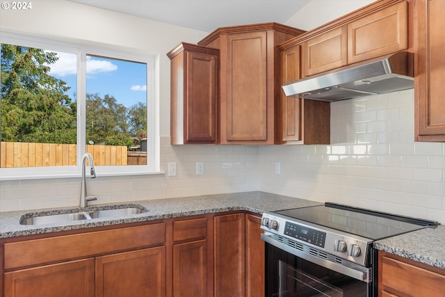 kitchen with sink, light stone countertops, stainless steel range with electric cooktop, and tasteful backsplash