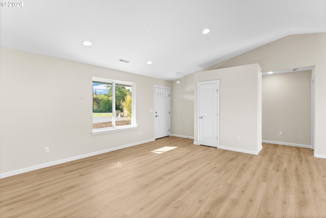 spare room with lofted ceiling and light hardwood / wood-style flooring