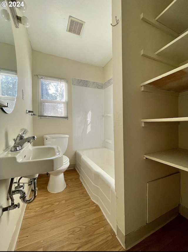 full bathroom with sink, toilet, tub / shower combination, and hardwood / wood-style flooring