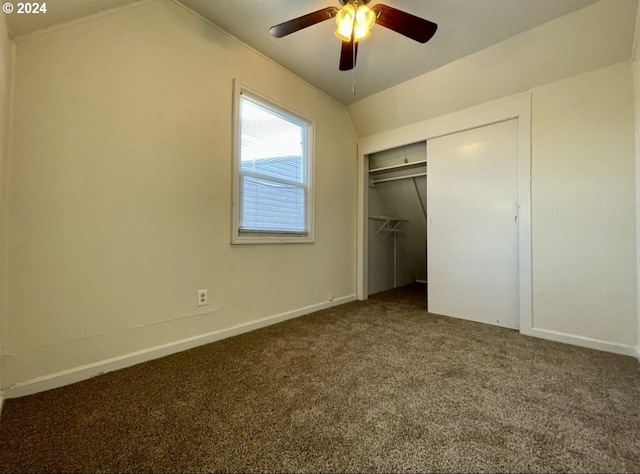 unfurnished bedroom featuring ceiling fan, a closet, carpet, and lofted ceiling