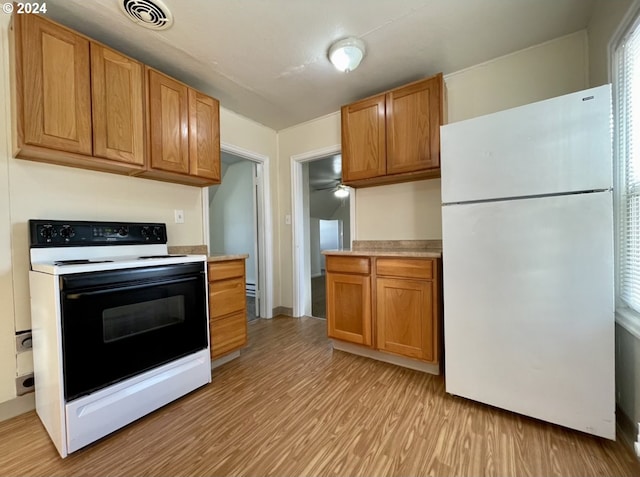 kitchen with light hardwood / wood-style floors and white appliances