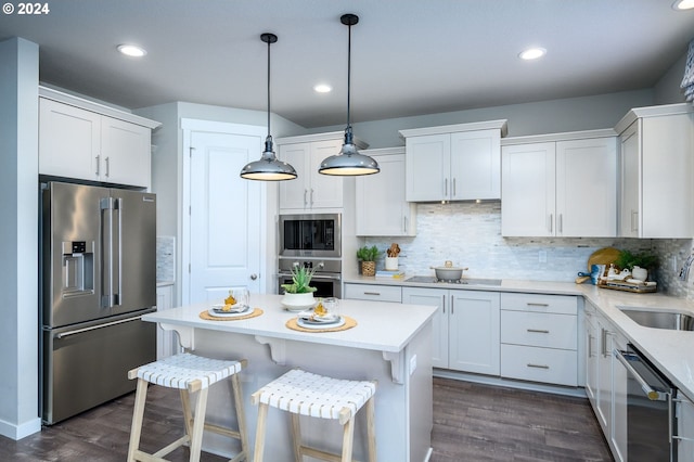 kitchen with white cabinets, dark hardwood / wood-style floors, decorative light fixtures, and appliances with stainless steel finishes