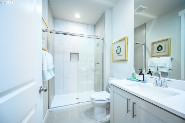 bathroom featuring vanity, toilet, and a shower with shower door