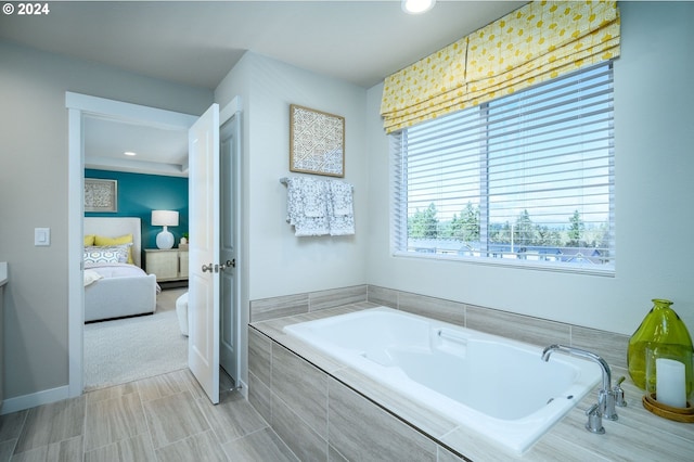 bathroom featuring vanity and tiled tub