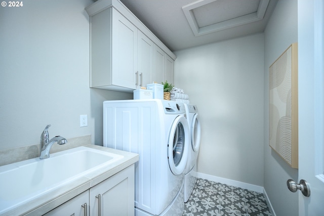 laundry area featuring cabinets, light tile patterned flooring, washing machine and dryer, and sink