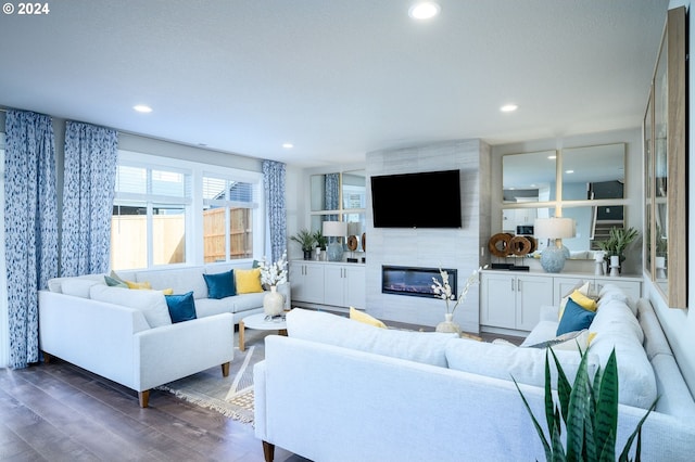 living room featuring dark hardwood / wood-style floors and a tiled fireplace